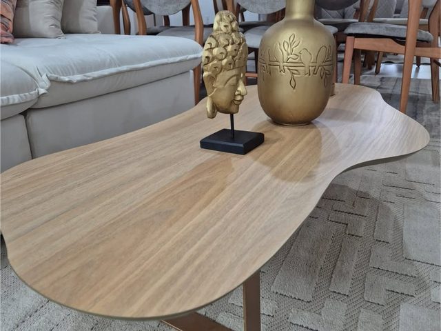 Mesa de centro orgânica de madeira com vasos dourados e esculturas decorativas